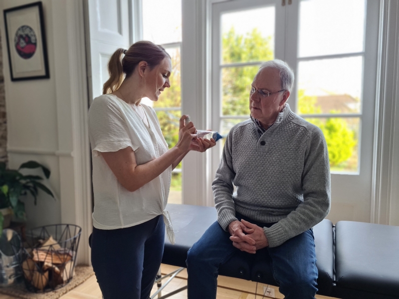 man receiving guidance on inhaler use at home
