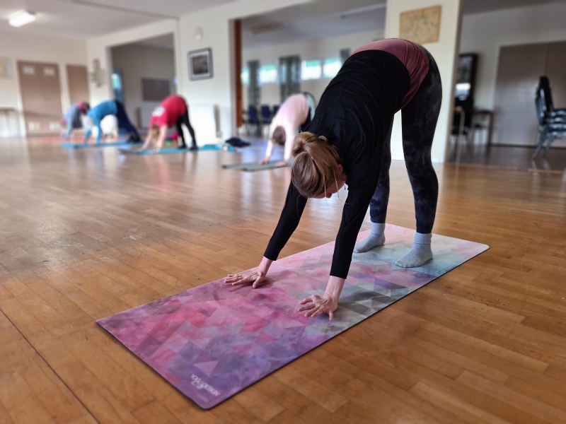 Lucy teaching a pilates class in the downward dog pose