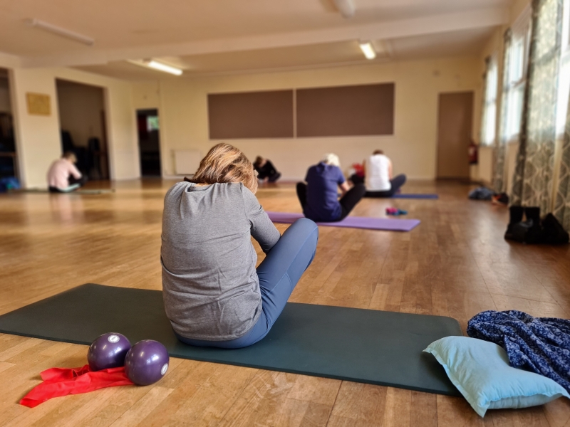 Pilates class all performing the butterfly stretch pose